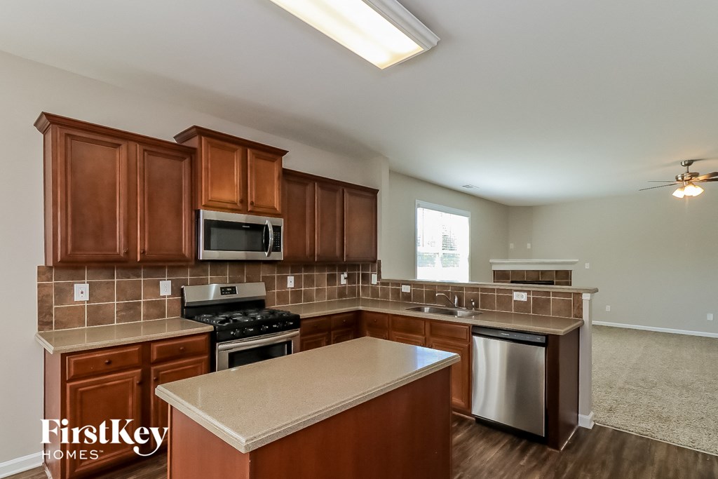 an empty kitchen with wooden cabinets and stainless steel appliances