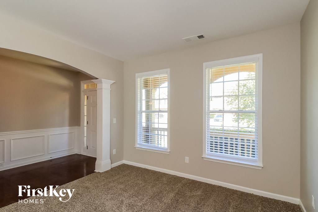 an empty room with two windows and a door