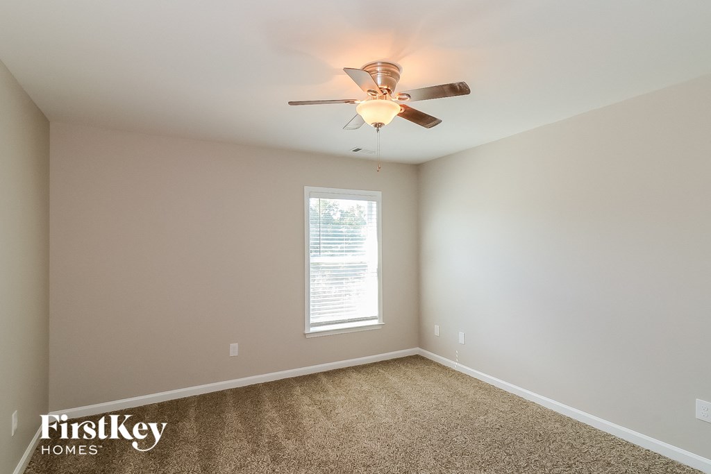 an empty room with a ceiling fan and a window