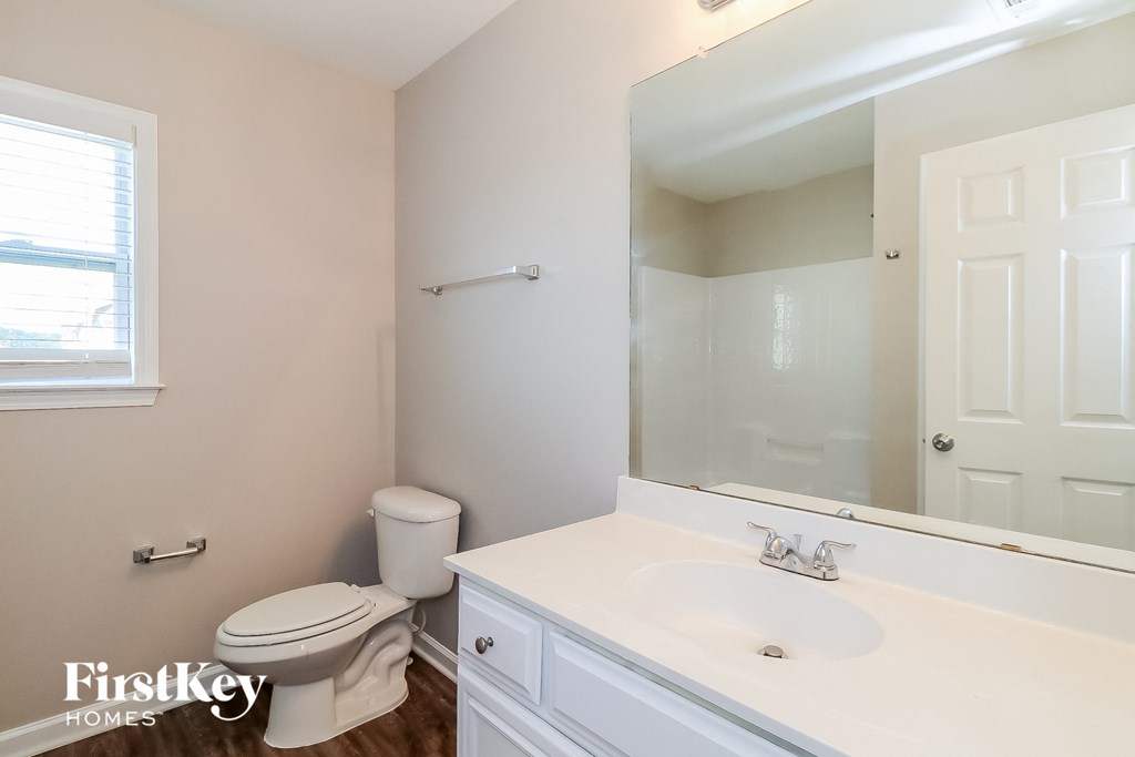 a bathroom with a toilet and a sink and a mirror