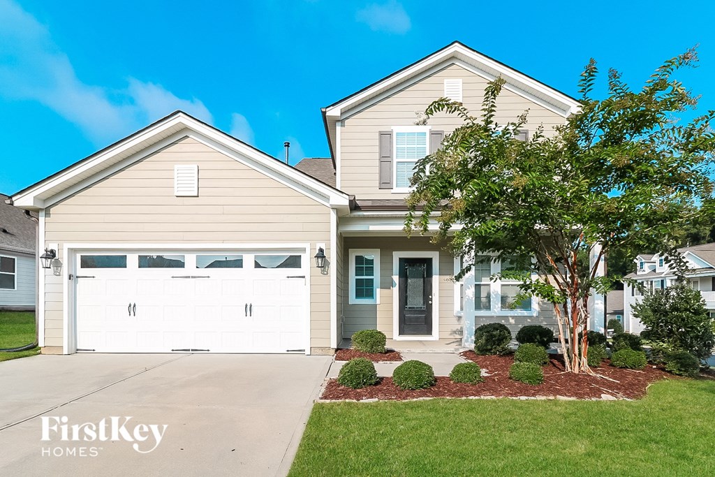 a beige house with a white garage door in front of a green lawn