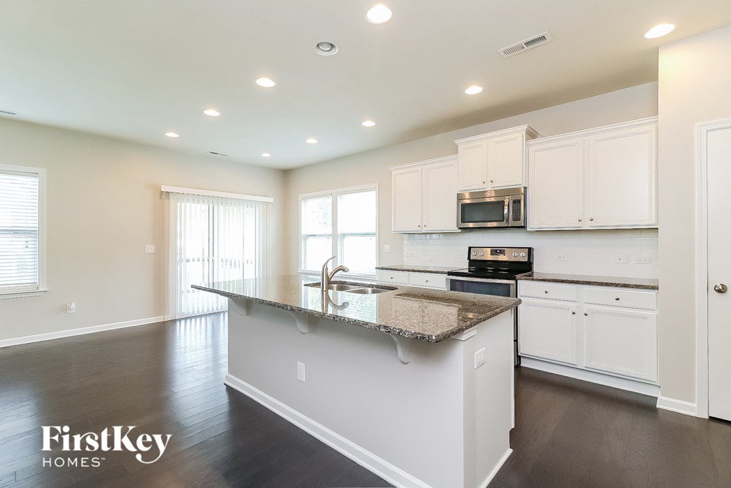 a kitchen with white cabinets and a granite counter top