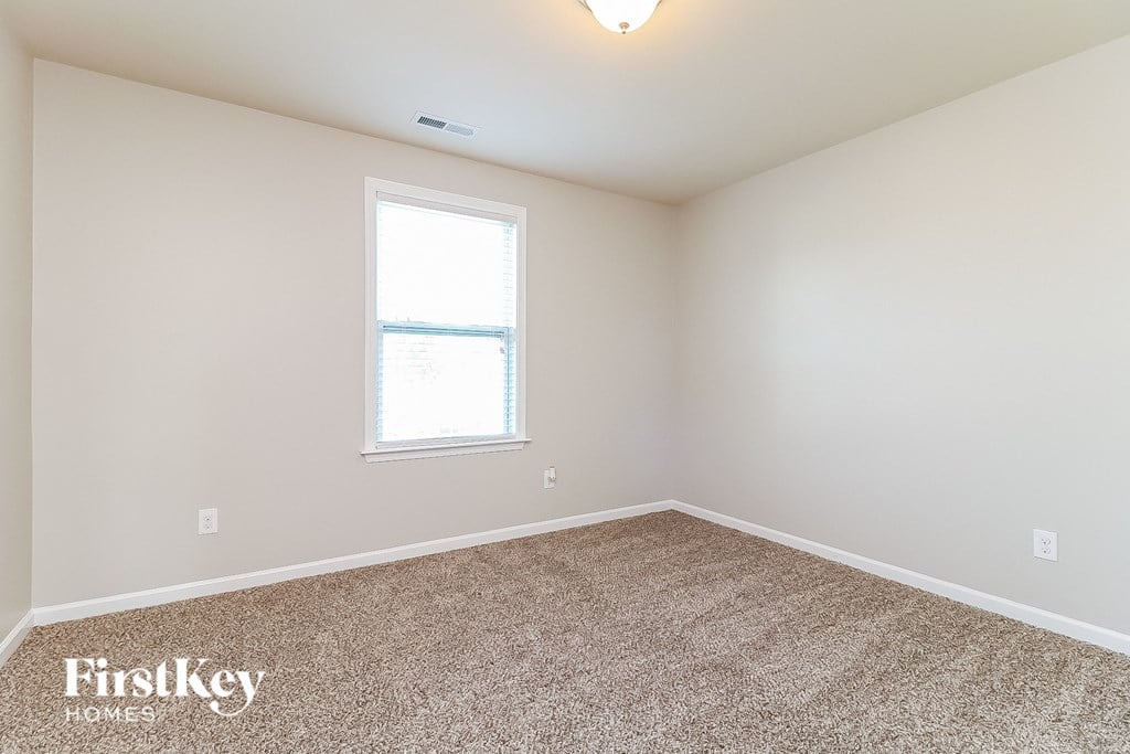 the second bedroom with carpet and a window
