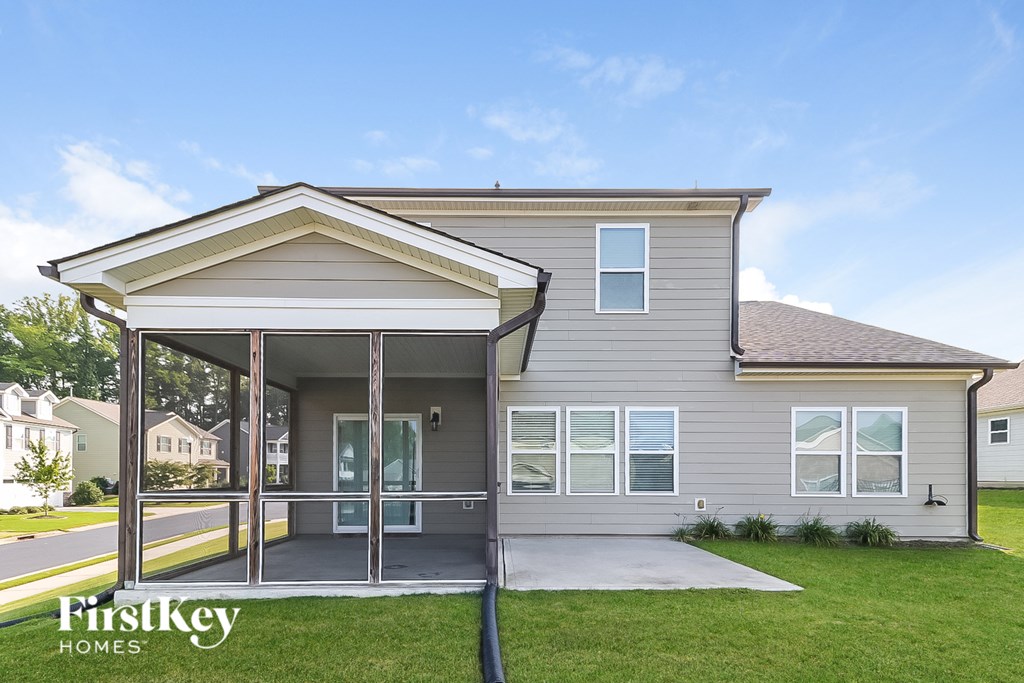 a gray house with a covered porch and a lawn