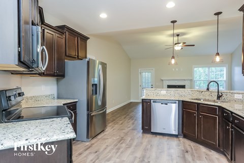 an updated kitchen with stainless steel appliances and marble counter tops