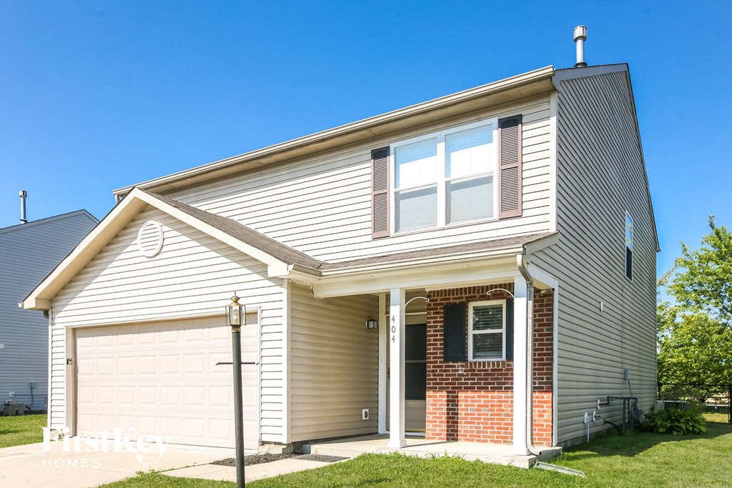a tan house with a white garage door