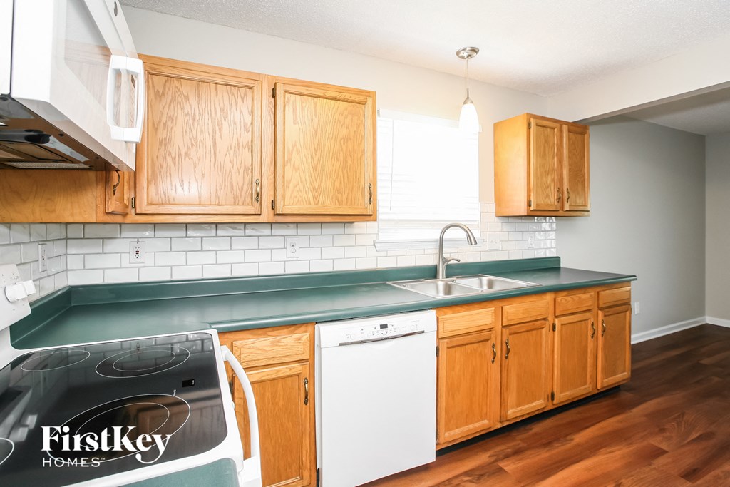 a kitchen with wood cabinets and white appliances and a green counter top