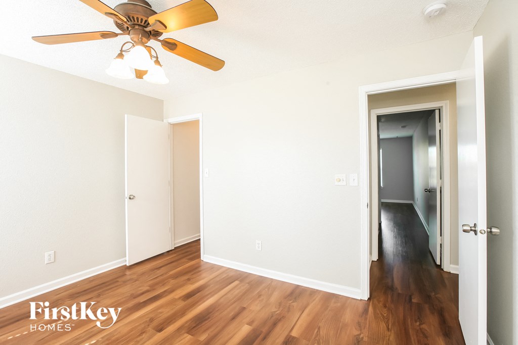 a living room with wood floors and a ceiling fan