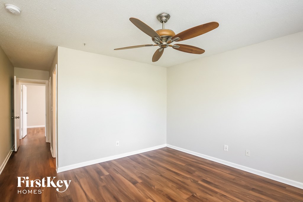 a living room with wood floors and a ceiling fan