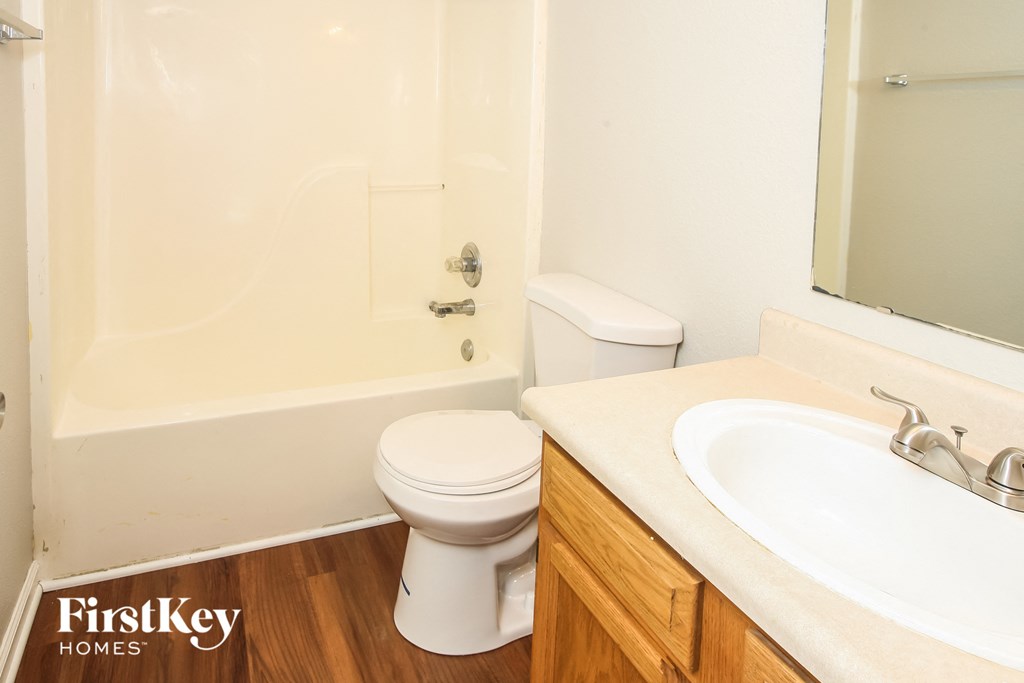 a bathroom with a toilet and a sink and a bath tub