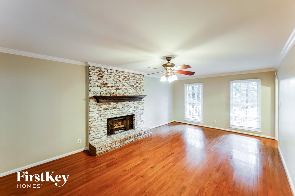 A room with a fireplace and wood flooring.