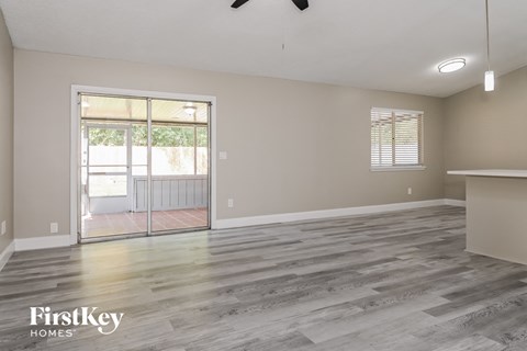 the living room and dining room with wood flooring and a sliding glass door