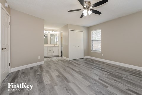 the master bedroom is spacious and has a large closet and a ceiling fan