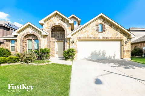 A house with a garage and a driveway in front of it.