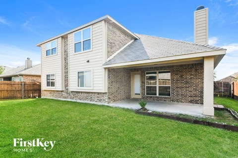 A house with a brick chimney and a grey roof.