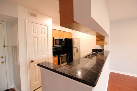 a kitchen with black granite counter tops and black appliances