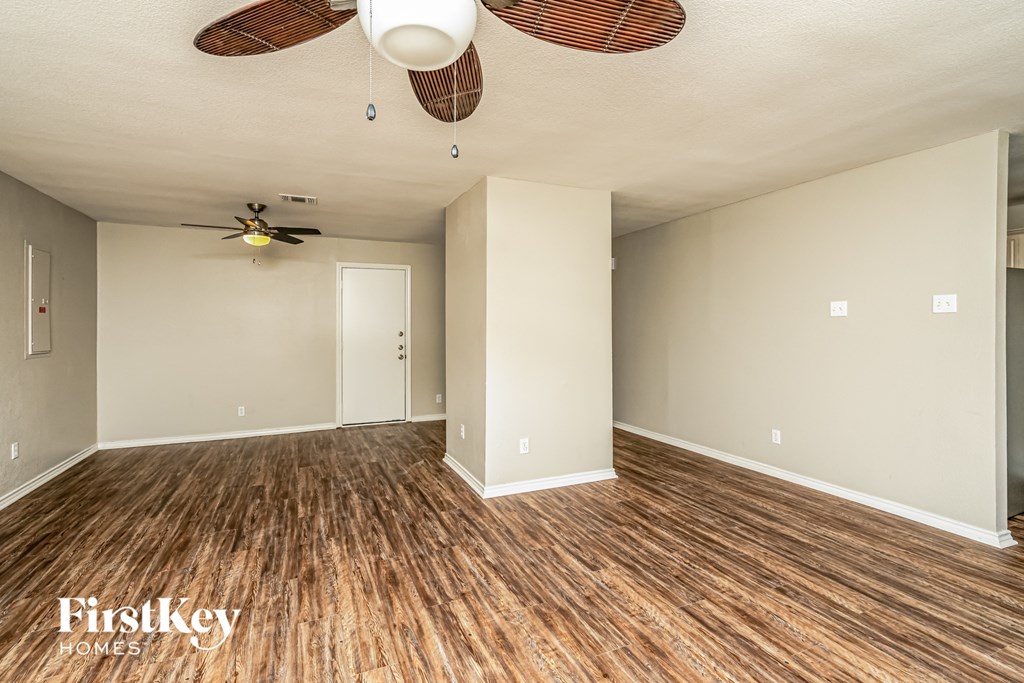 A room with wooden floors and a ceiling fan.