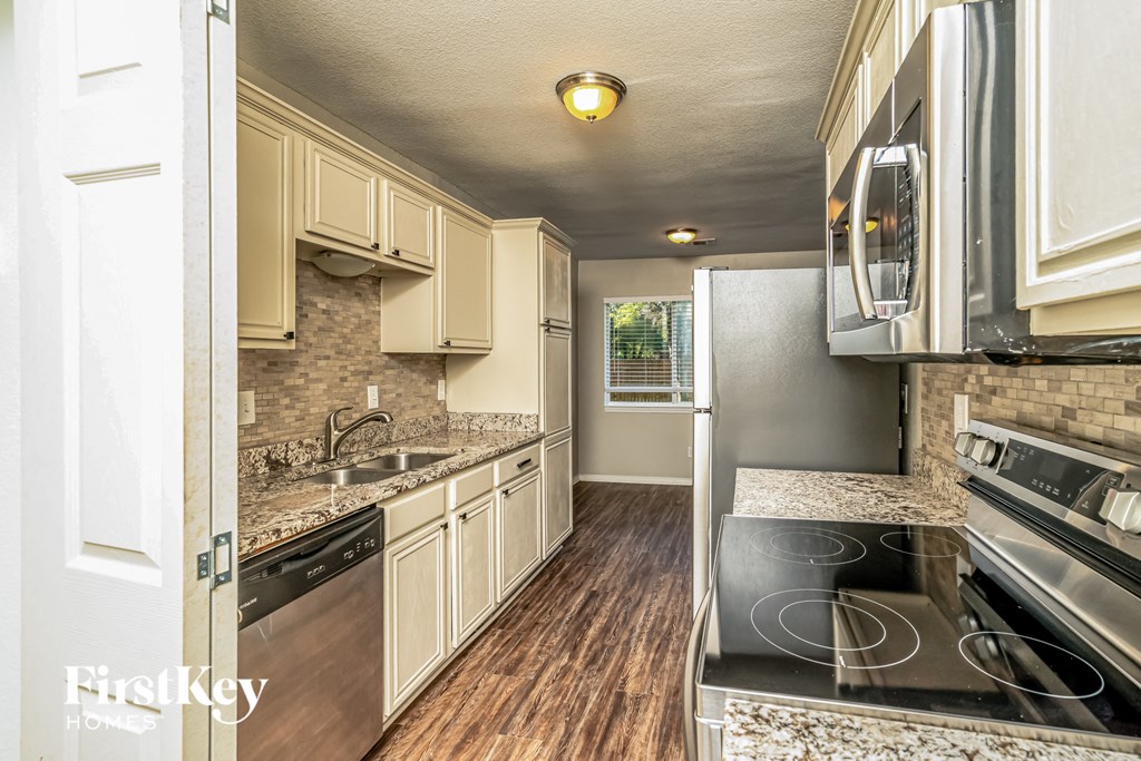 A kitchen with a stove top oven and a microwave above it.