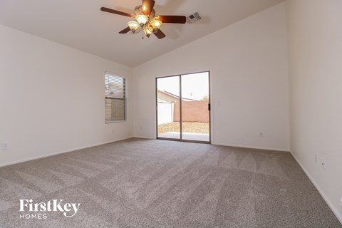 the living room of an empty house with a ceiling fan