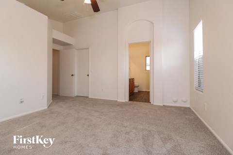 an empty living room with a carpeted floor and a door to a bedroom