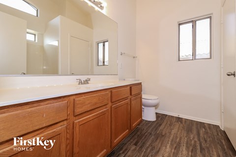a bathroom with wooden cabinets and a sink and a toilet