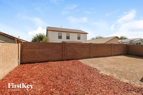 a retaining wall in a backyard with a house in the background