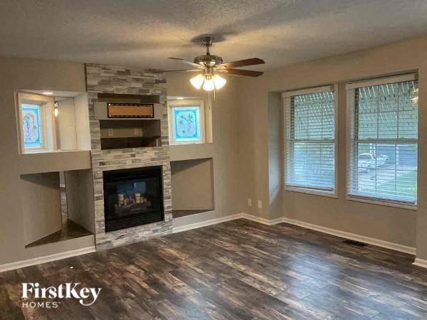 a living room with a fireplace and a ceiling fan