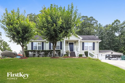 a white house with a lawn and trees