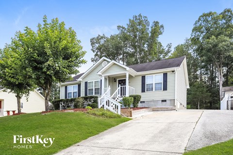 a yellow house with blue shutters and a driveway
