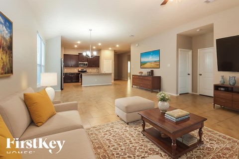 A spacious living room with a couch, coffee table, and a painting on the wall.
