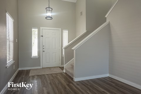 the entryway of a home with a staircase and a white door