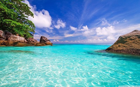 A beautiful beach with clear blue water and rocks.