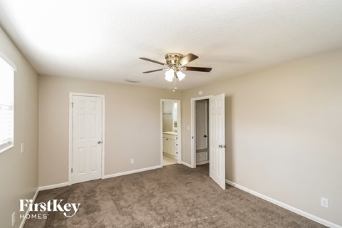 a living room with carpet and a ceiling fan