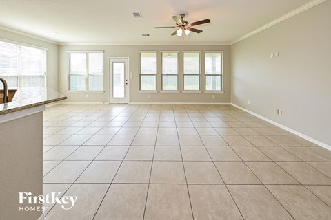 an empty living room with a ceiling fan