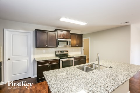 A kitchen with granite countertops and wooden cabinets.
