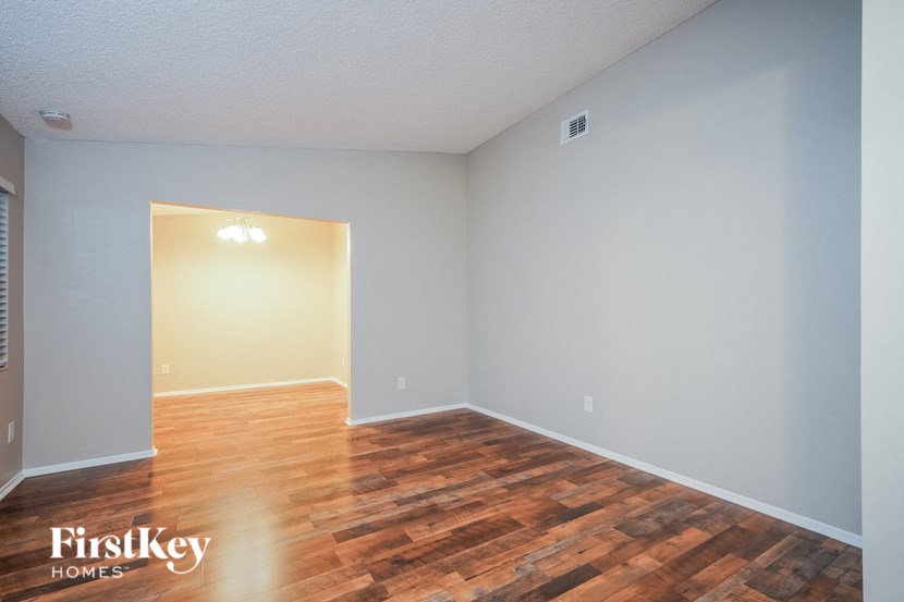A room with wooden flooring and a light on the wall.