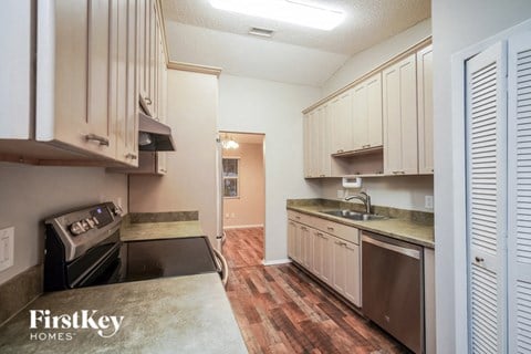A kitchen with wooden cabinets and a stove top oven.