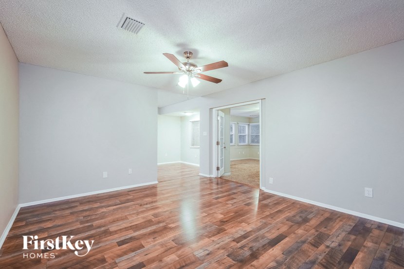 A room with wooden floors and a ceiling fan.