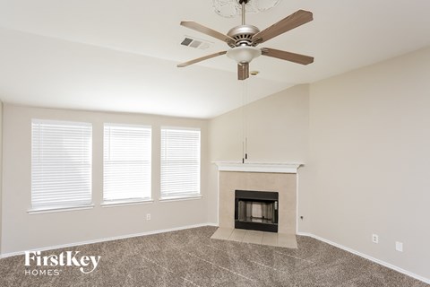 A room with a fireplace and a ceiling fan.