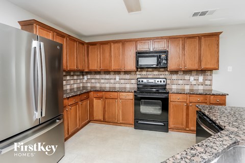 A kitchen with wooden cabinets and a stainless steel refrigerator.