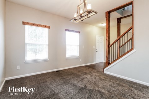 A spacious room with a staircase leading to another room.