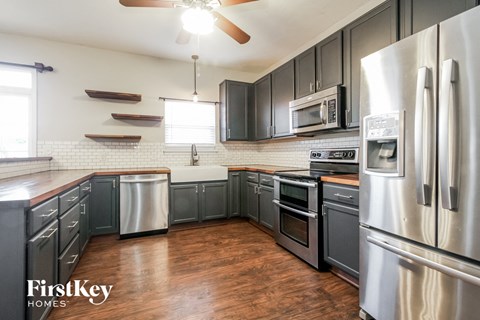 A kitchen with wooden floors and stainless steel appliances.