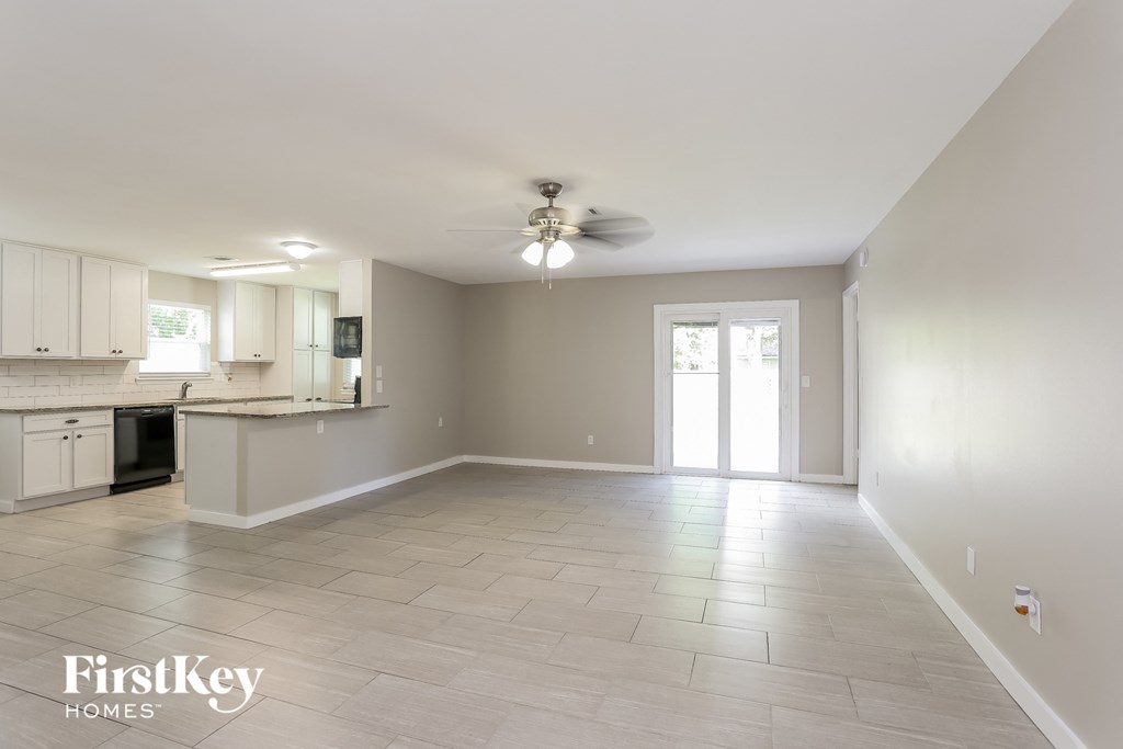 an empty kitchen and living room with a ceiling fan