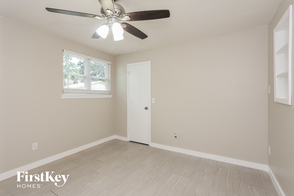 an empty room with a ceiling fan and a window