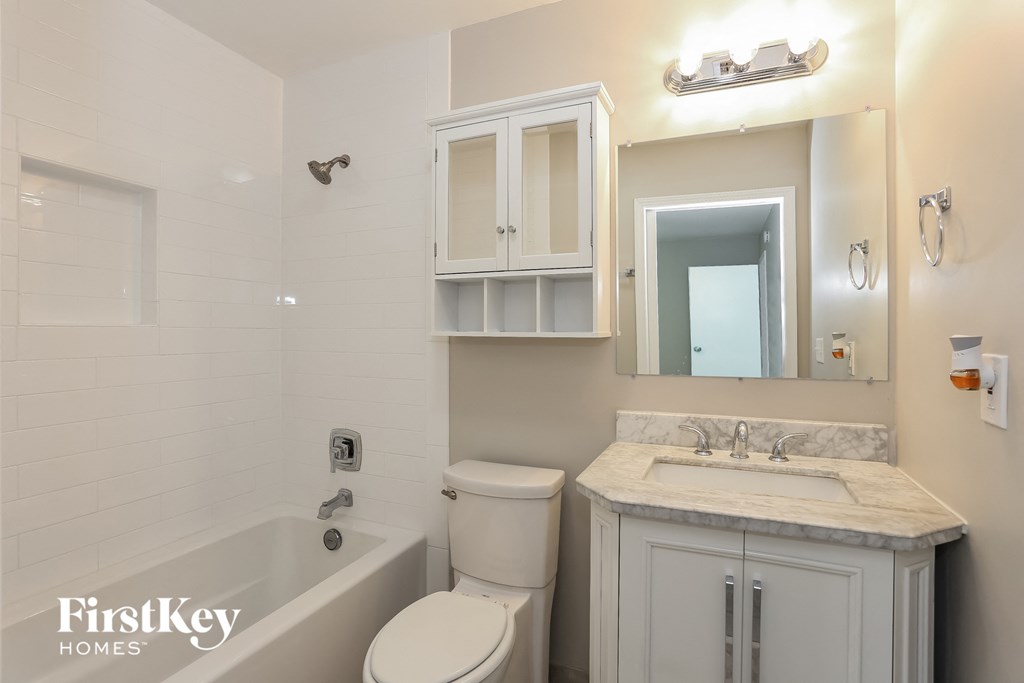 a white bathroom with a sink toilet and bath tub