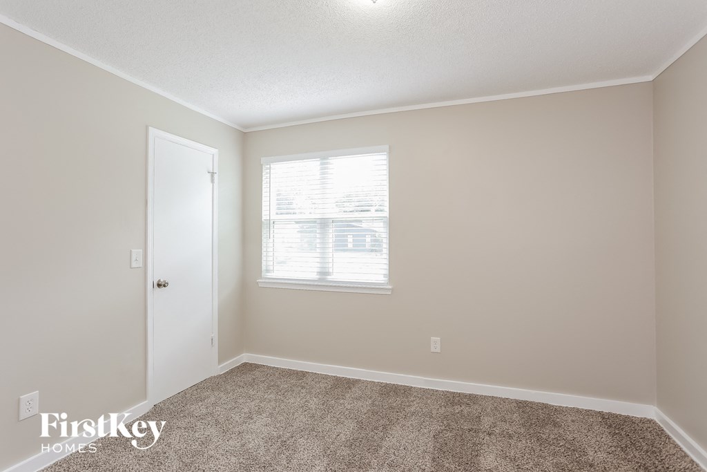 a bedroom with a carpeted floor and a window