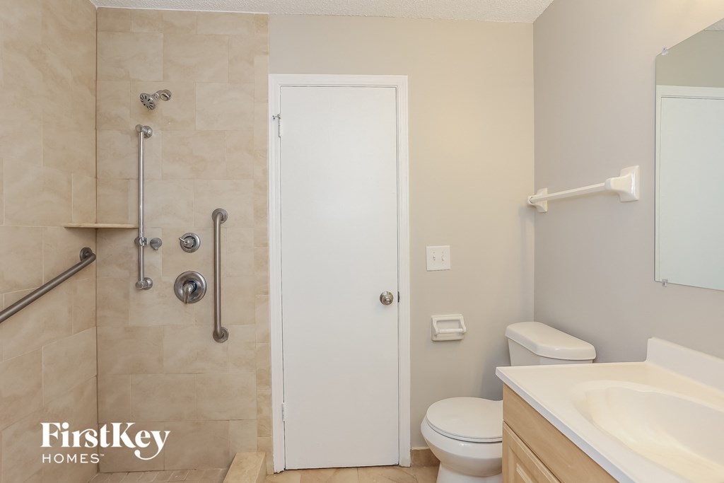a bathroom with a shower toilet and sink and a mirror