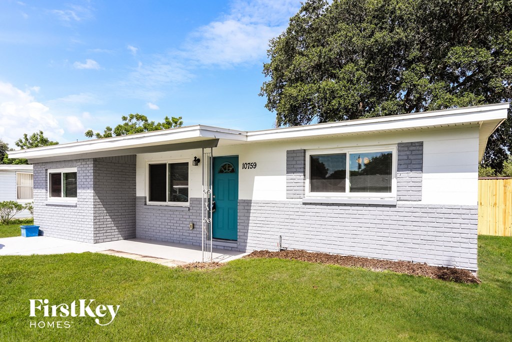 a white brick house with a blue door