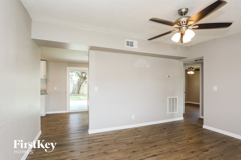 the living room and dining room with a ceiling fan