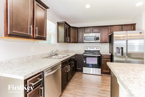 A kitchen with brown cabinets and stainless steel appliances.
